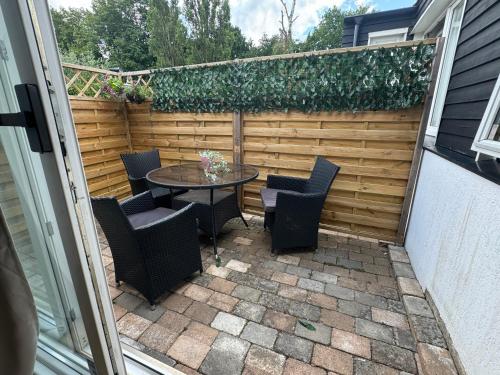 eine Terrasse mit Tisch und Stühlen und einem Zaun in der Unterkunft Lägenhet i Limhamn/sibbarp in Malmö