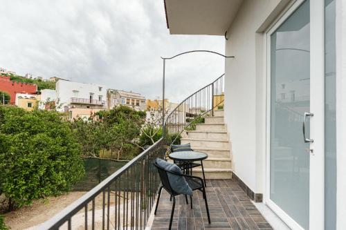 ein Balkon mit zwei Stühlen und einem Tisch in der Unterkunft Il Poeta nella Vigna in Procida