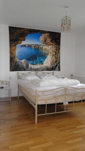 un lit dans une chambre avec un tableau sur le mur dans l'établissement FRONT DE MER, meublé de tourisme sur le port, à Grandcamp-Maisy