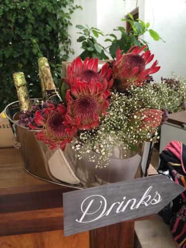 a table with a bouquet of flowers and a sign at Avoca River Cabins in Addo