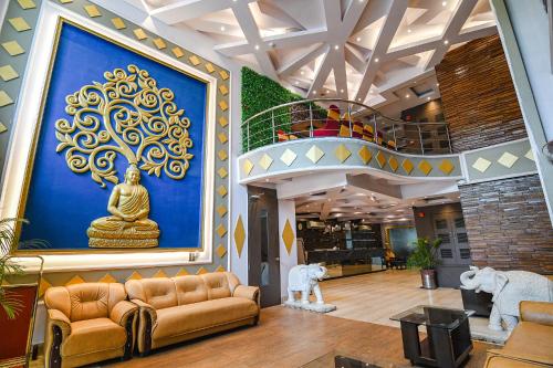a lobby with a large painting of a buddha on the wall at FabHotel Shivani International in Rānchī