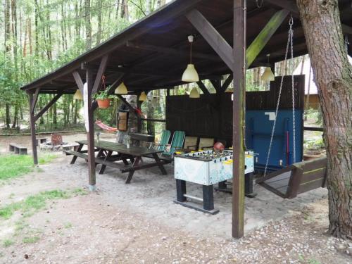 a picnic shelter with a ping pong table in the woods at Grubałówka in Rogówko