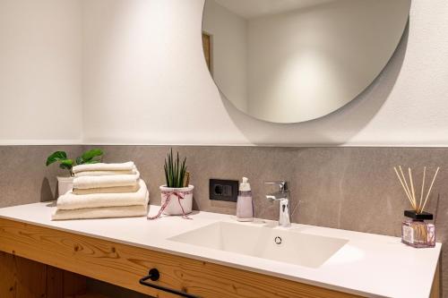 un bagno con un lavandino bianco e uno specchio di Villa Anna Villnöss a San Pietro