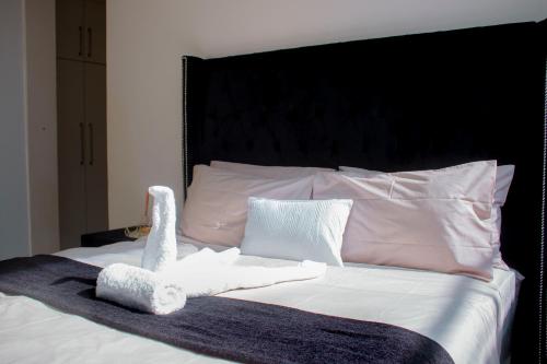 a bed with a stuffed animal on top of it at Guest House Auasblick by State House in Windhoek
