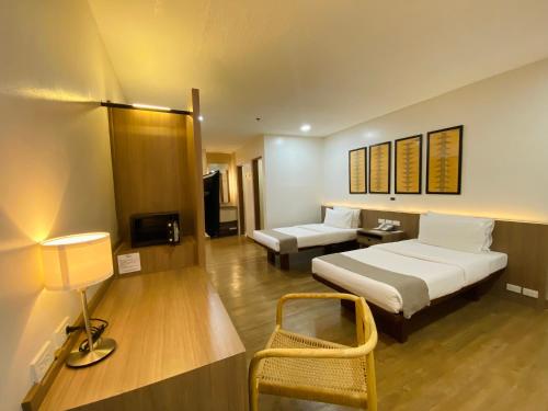 a hotel room with a bed and a desk with a tv at Nature's Village Resort in Bacolod