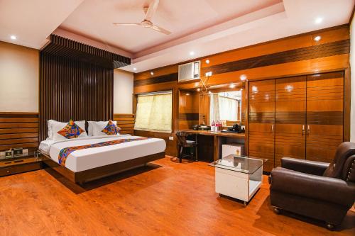 a bedroom with a bed and a desk and a chair at FabHotel Shivani International in Rānchī