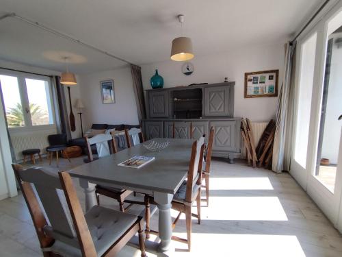 une salle à manger et un salon avec une table et des chaises dans l'établissement Villa de Jo, à Grand-Village-Plage