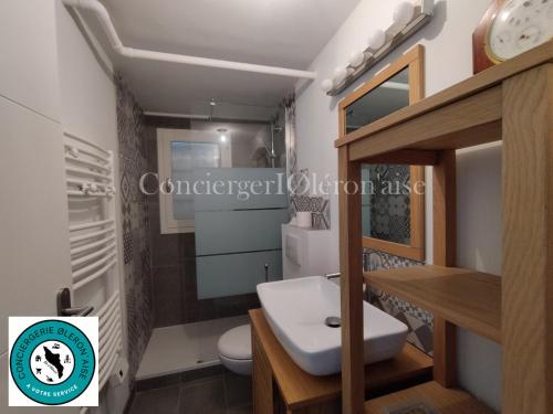 une salle de bain avec des toilettes blanches et un lavabo dans l'établissement Villa de Jo, à Grand-Village-Plage