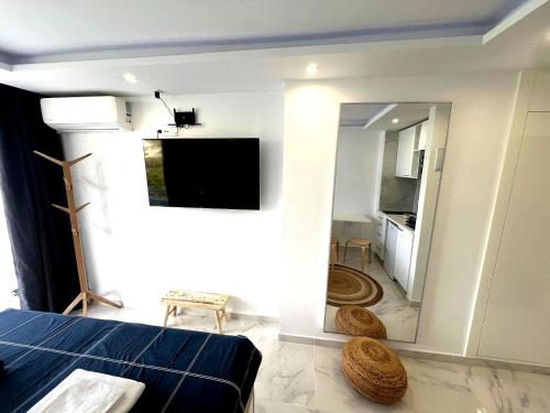 a living room with a bed and a tv on a wall at Tenerife Sea View Sun Beach Apartment 214 in Playa Fañabe