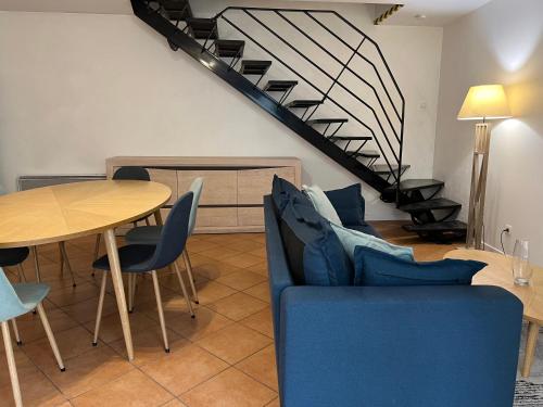 a living room with a blue couch and a table at Triplex à La Roche de Glun in La Roche-de-Glun