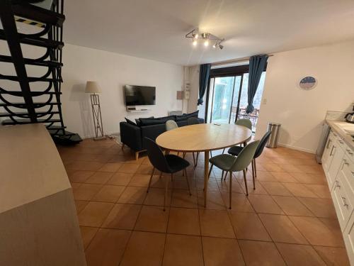 a kitchen and living room with a table and chairs at Triplex à La Roche de Glun in La Roche-de-Glun