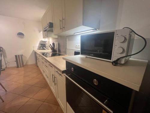 a kitchen with a microwave on top of a counter at Triplex à La Roche de Glun in La Roche-de-Glun