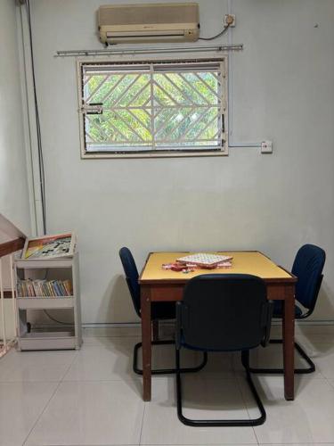 a table and chairs in a room with a window at Comfortable Retreat in Megah Ria in Masai