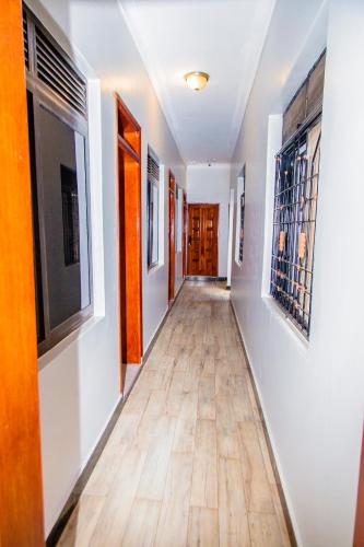 a hallway with white walls and a wooden floor at Belmont Villas Mbale in Mbale