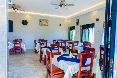 a restaurant with tables and chairs and a ceiling fan at Belmont Villas Mbale in Mbale