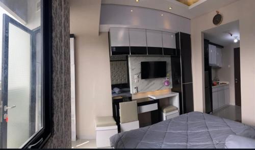 a small room with a bed and a kitchen at Levi Begawan Apartment in Blimbing