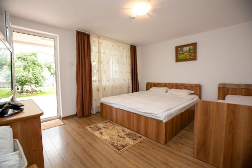 a bedroom with a bed and a large window at Casa Mădălina in Oeștii Ungureni
