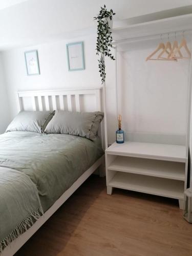 a white bedroom with a bed and a night stand at Central Sligo Townhouse in Sligo