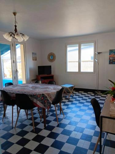 un salon avec une table et des chaises dans l'établissement Maison charmante à Port-Bail-sur-Mer, grand jardin clos, à Port-Bail-sur-Mer