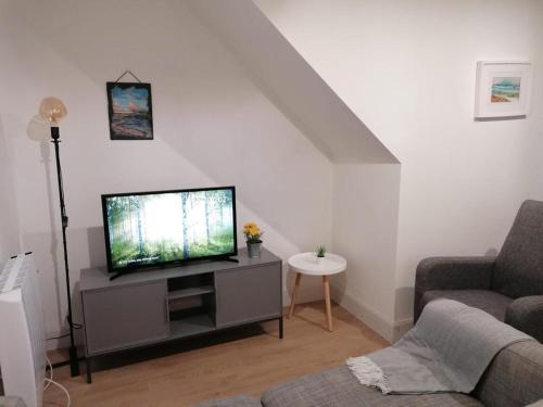 a living room with a flat screen tv on a cabinet at Central Sligo Townhouse in Sligo