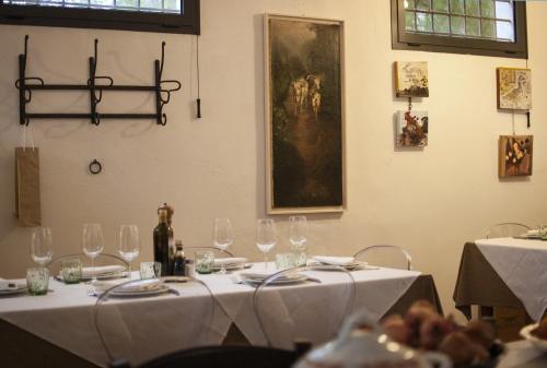 a table with wine glasses and a painting on the wall at La Lepre Bianca in Cento