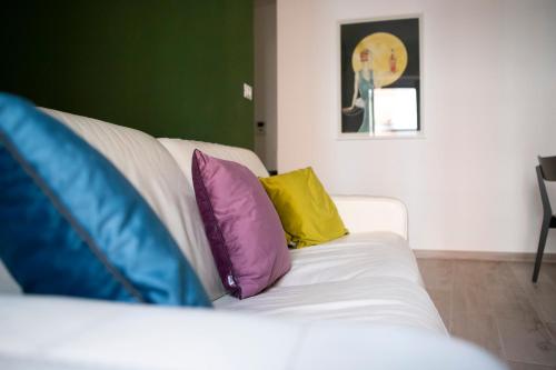 a white couch with two colorful pillows on it at San Rocco 8 Centro Orbassano in Orbassano