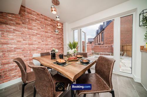 a dining room with a brick wall and a wooden table at Manchester 3-Bed House l Free Parking l WiFi l Your Home Away From Home hosted by The Cosy Corner Nationwide in Manchester