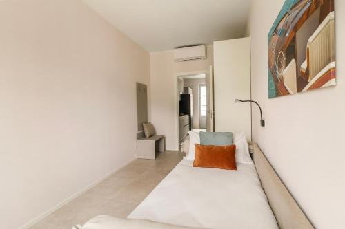 a white room with a couch with a pillow on it at Como City Wall in Como