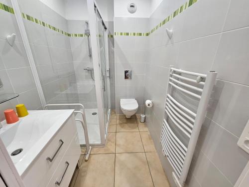 une salle de bain blanche avec toilettes et douche dans l'établissement PAOLINA C9 - CLIM - WIFI - VUE MER, à Sari-Solenzara
