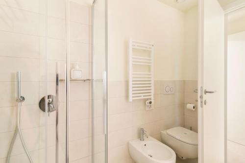 a white bathroom with a shower and a toilet at Como City Wall in Como