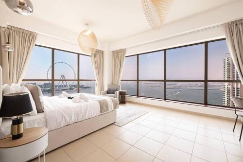 a bedroom with a large bed and a large window at Dubai Eye & Sea View, 1-min walk to JBR Beach, Luxurious Beach Retreat! in Dubai
