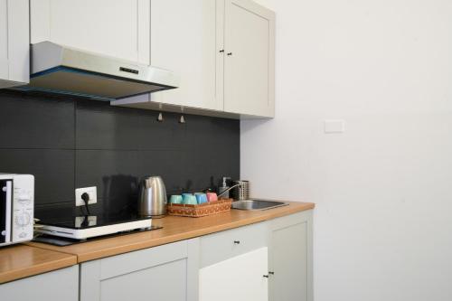 a kitchen with white cabinets and a counter top at Maison Turin in Turin