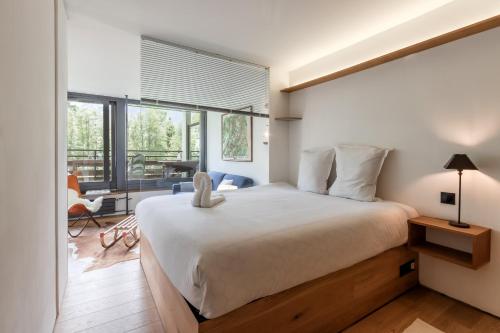 une chambre avec un grand lit et une grande fenêtre dans l'établissement Lac des Gaillands - Renove - Balcon avec vues, à Chamonix-Mont-Blanc