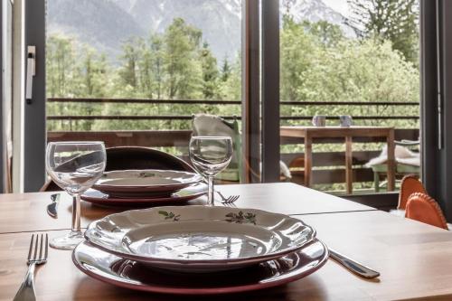 une table avec des verres et des assiettes sur une table avec vue dans l'établissement Lac des Gaillands - Renove - Balcon avec vues, à Chamonix-Mont-Blanc