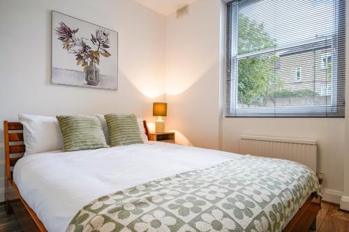 a bedroom with a large white bed with a window at Hububb Luxury Apartment Ealing in Ealing