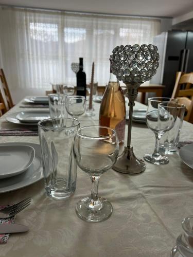 a table with wine glasses and plates on a table at Casa Mădălina in Oeștii Ungureni