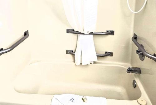 a bath tub with a towel hanging on a wall at Days Inn by Wyndham North Sioux City in North Sioux City