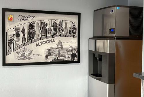 a picture hanging on a wall next to a refrigerator at Super 8 by Wyndham Altoona in Altoona