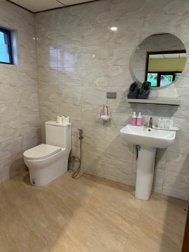 a bathroom with a toilet and a sink and a mirror at Chaweng Bliss Bungalow in Chaweng