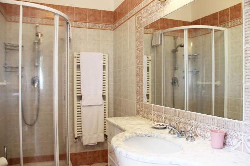 a bathroom with a sink and a shower and a mirror at Villa Amaranto in Panzano