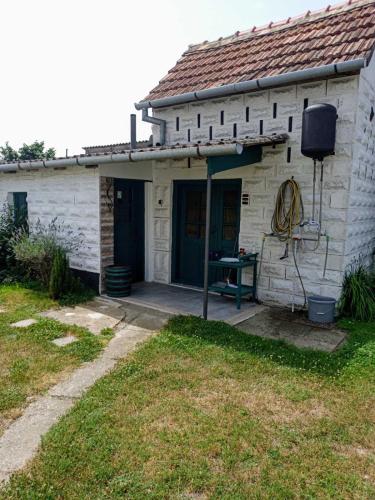 a small white building with a yard in front of it at Kuća za odmor BIĐ in Šiškovci