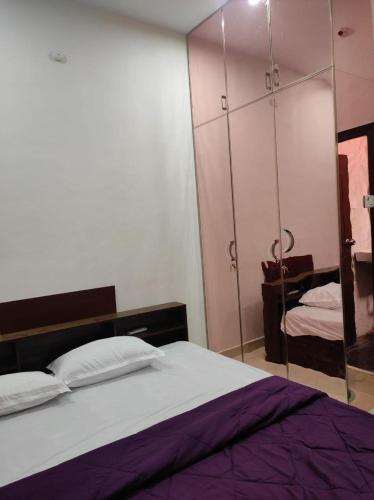 a bedroom with a bed and a mirrored cabinet at Home Stay Near Airport in Chennai