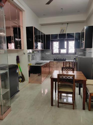 a large kitchen with a wooden table and chairs at Home Stay Near Airport in Chennai
