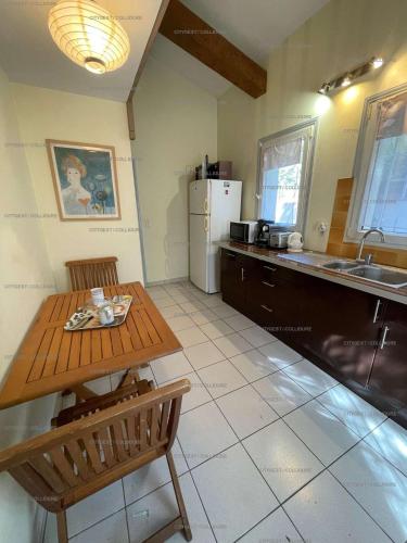 - une cuisine avec une table en bois et un évier dans l'établissement 2DUF11 - Maisonnette hauts de Collioure climatisée, à Collioure