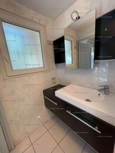 une salle de bain avec un lavabo et un miroir dans l'établissement 2DUF11 - Maisonnette hauts de Collioure climatisée, à Collioure