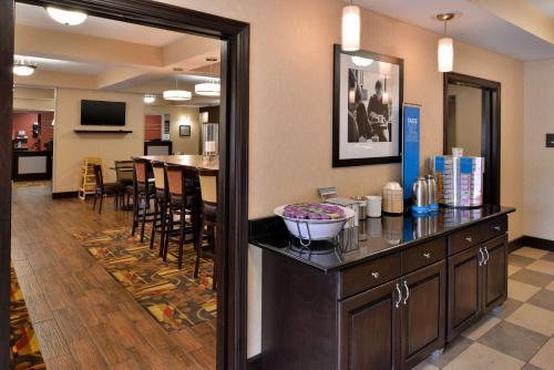 a hotel room with a bar with a dining room at Wingate by Wyndham Steubenville in Steubenville