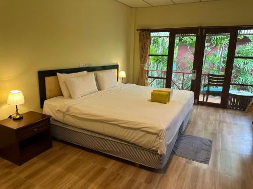 a bedroom with a bed and a table with a lamp at Chaweng Bliss Bungalow in Chaweng