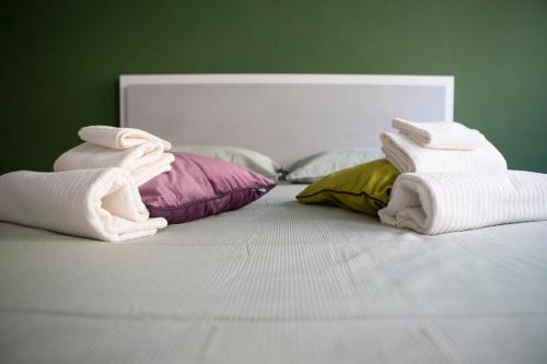 a bed with towels and pillows on it at San Rocco 8 Centro Orbassano in Orbassano
