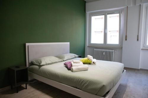 a green bedroom with a bed with towels on it at San Rocco 8 Centro Orbassano in Orbassano
