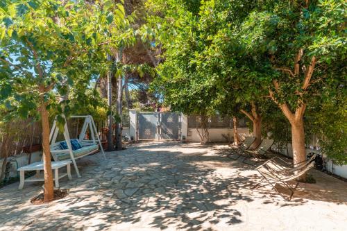 a yard with trees and a swing in the shade at La maison de Rosetta al mare in Specchiolla 